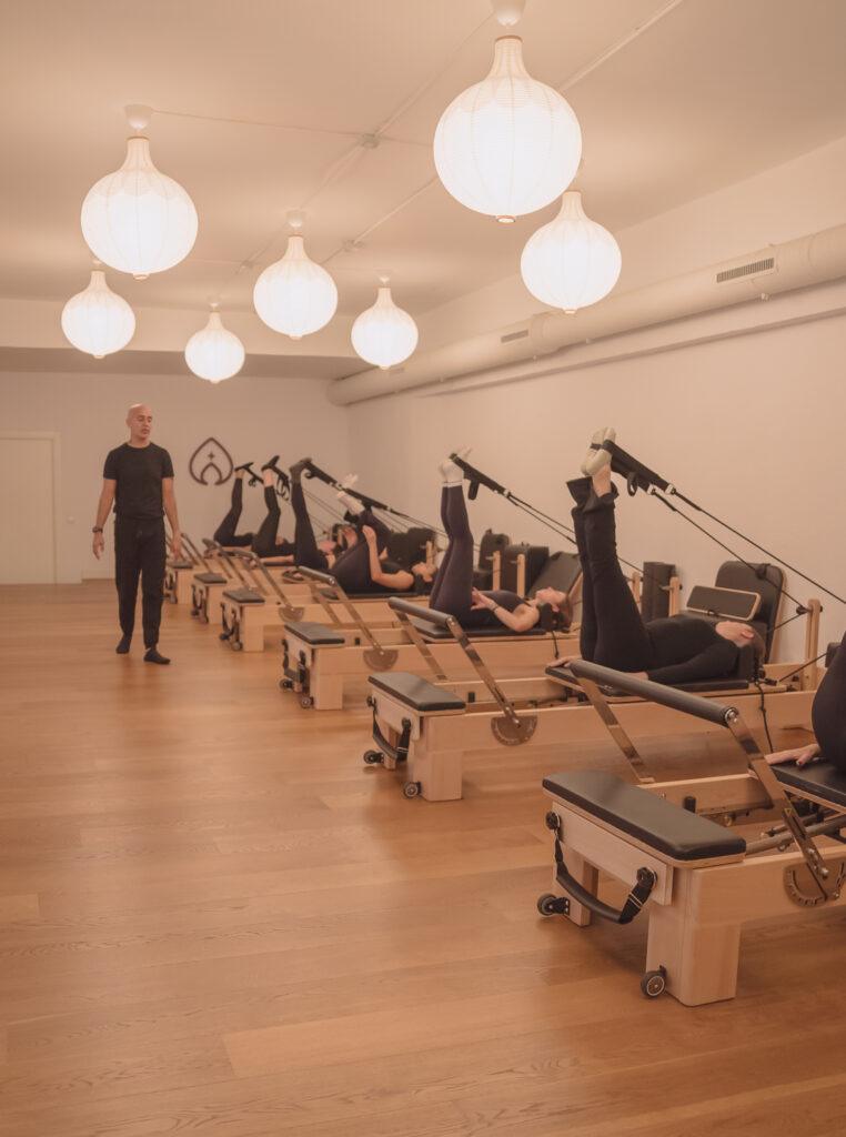 Instructor dirigiendo clase de pilates reformer en Pinar Pilates