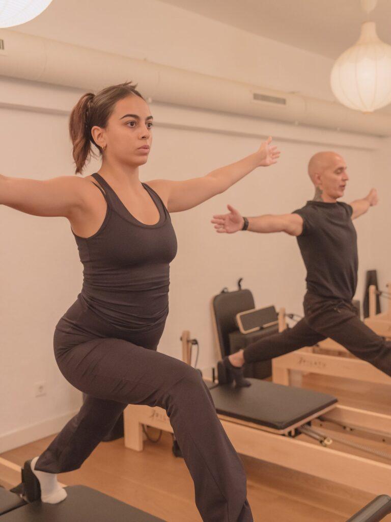 Ejercicio de fuerza de pie sobre el reformer en Pinar Pilates Madrid