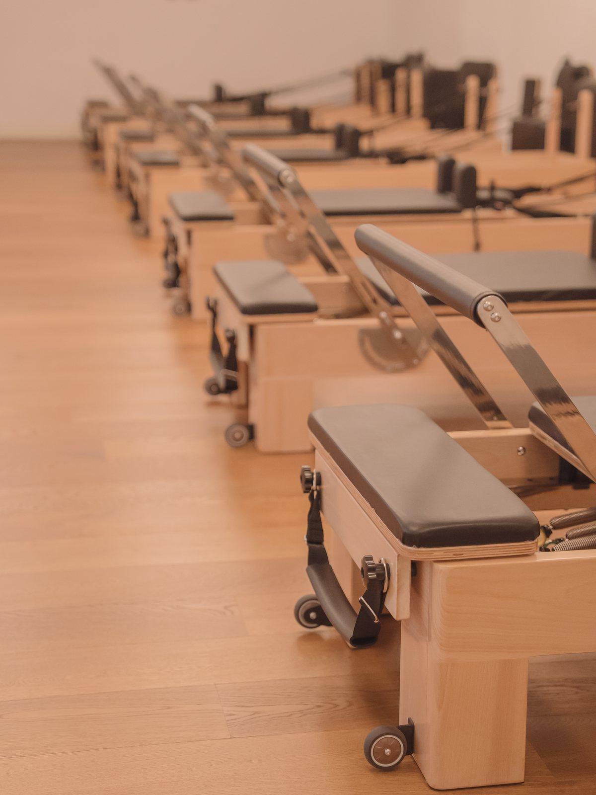 Máquinas reformer clásicas alineadas en un estudio de pilates en Madrid