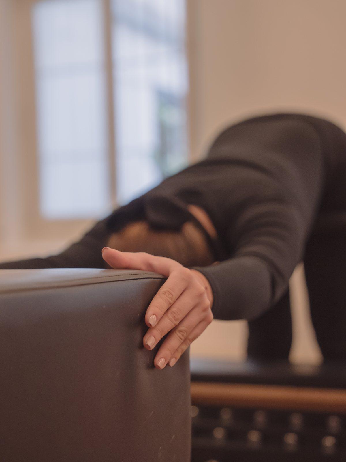 Manos apoyadas en el reformer durante un ejercicio suave, Pinar Pilates Madrid