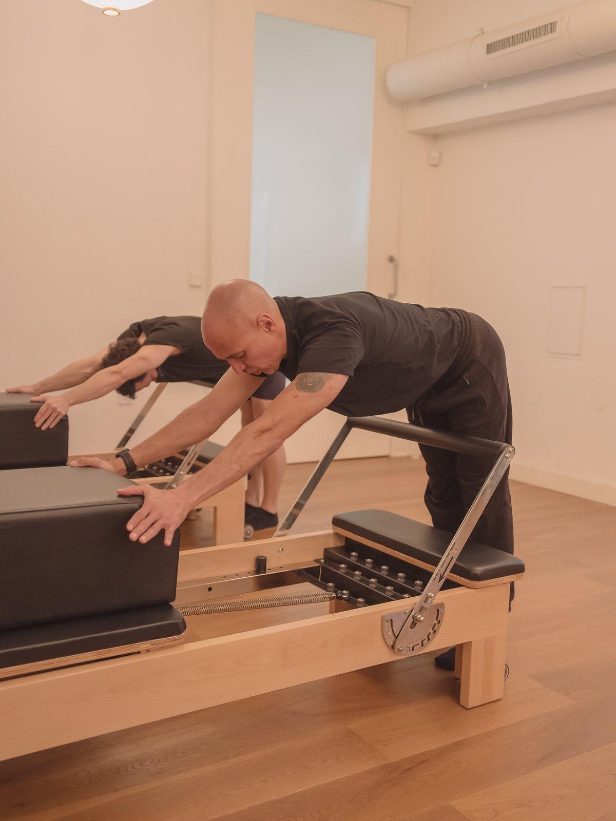 Instructor corrigiendo la posición de cadera sobre el reformer en Madrid