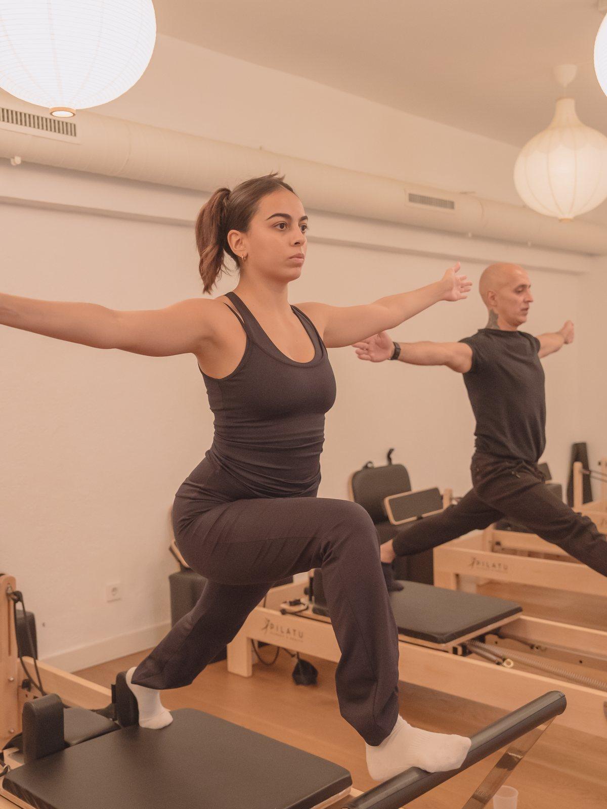 Ejercicio de fuerza de pie sobre el reformer en Pinar Pilates Madrid