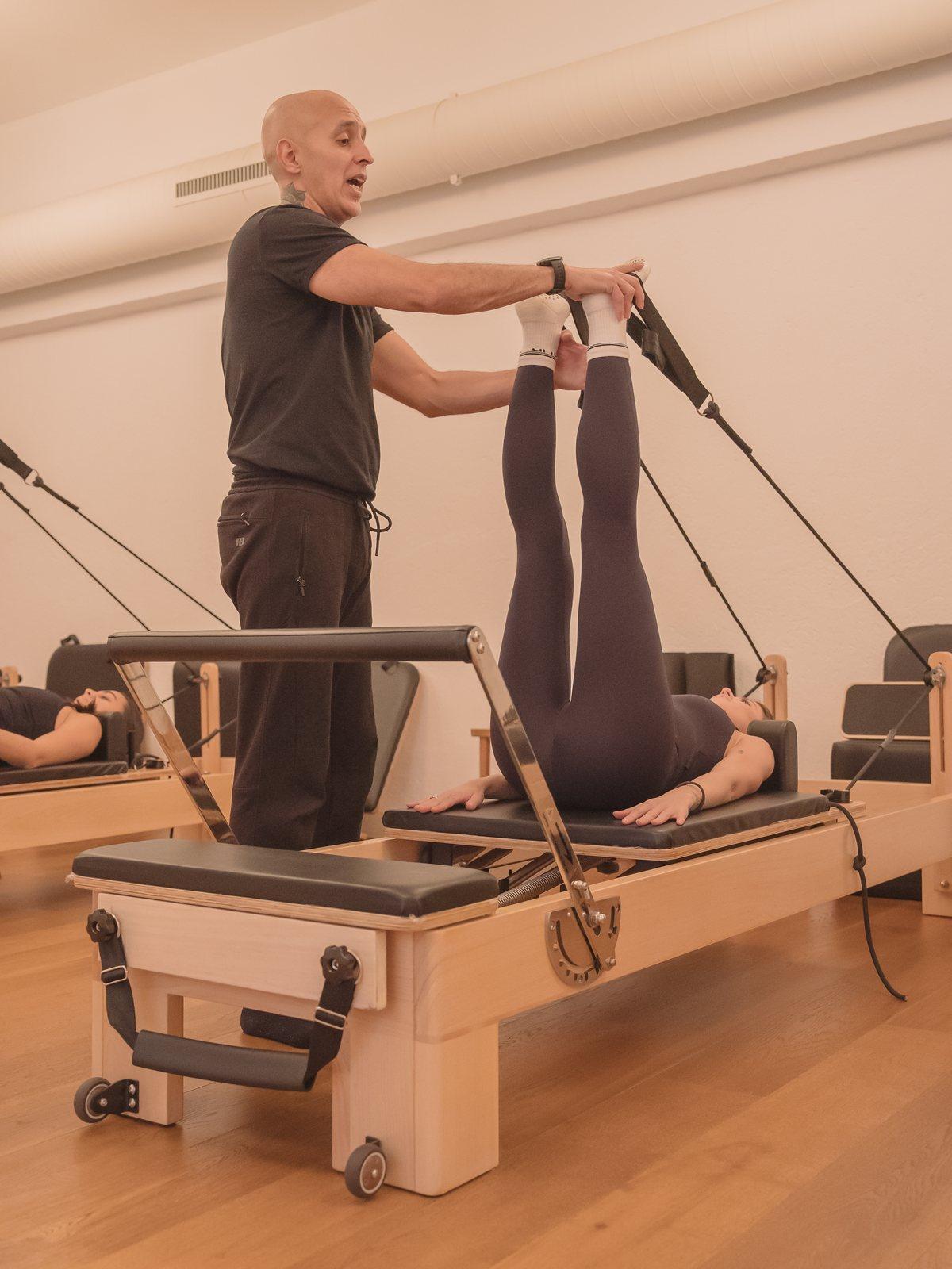 Instructor asistiendo a una alumna en el reformer, Pinar Pilates Madrid